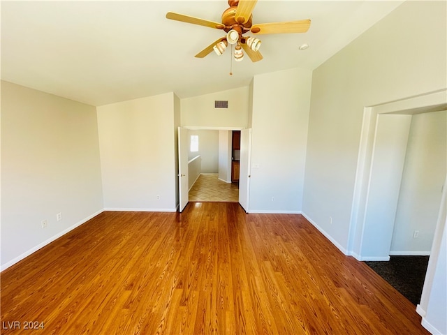 empty room with hardwood / wood-style flooring, ceiling fan, and lofted ceiling