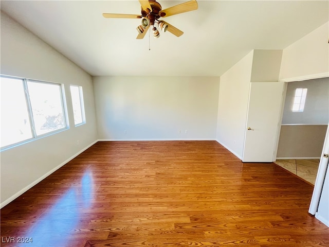 empty room featuring ceiling fan, plenty of natural light, and wood-type flooring