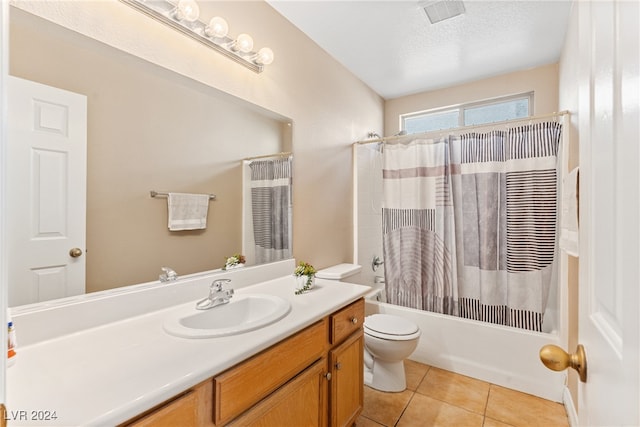 full bathroom with a textured ceiling, shower / bath combo, toilet, vanity, and tile patterned flooring