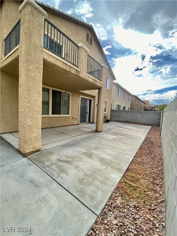 back of property featuring a patio area and a balcony