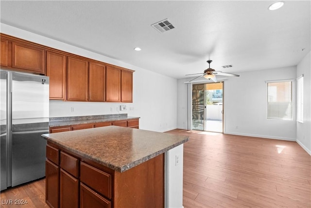 kitchen with ceiling fan, high end refrigerator, light hardwood / wood-style floors, and a kitchen island