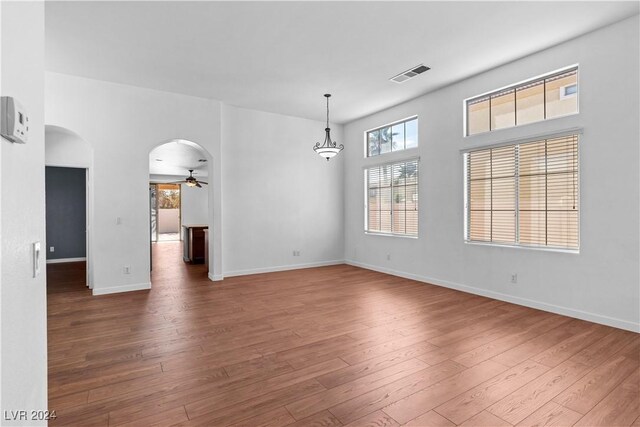 empty room with dark wood-type flooring and ceiling fan