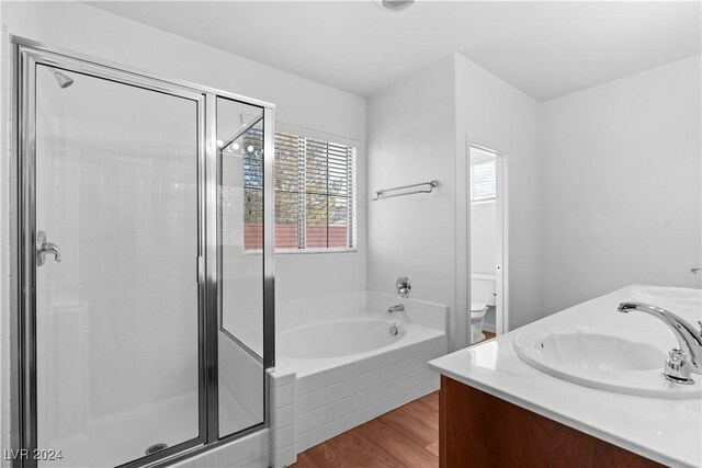 full bathroom with vanity, toilet, hardwood / wood-style floors, and shower with separate bathtub