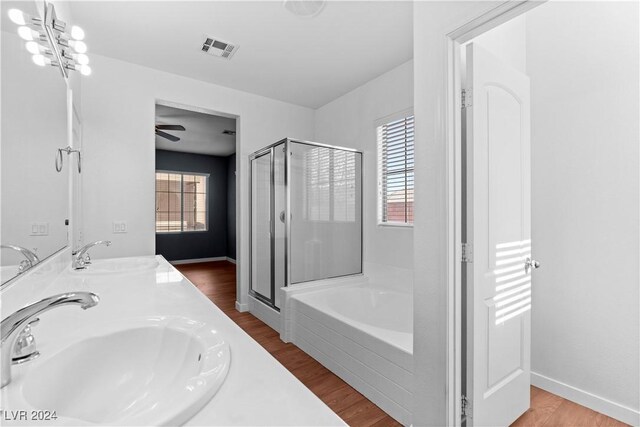 bathroom with a healthy amount of sunlight, separate shower and tub, and hardwood / wood-style floors