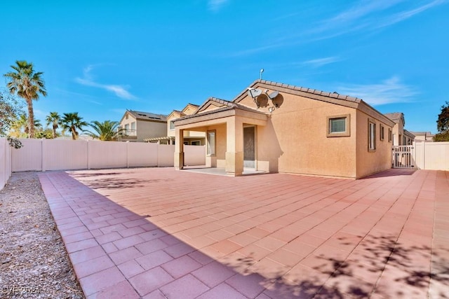 back of house with a patio, a fenced backyard, and stucco siding
