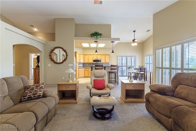 carpeted living room featuring high vaulted ceiling and ceiling fan