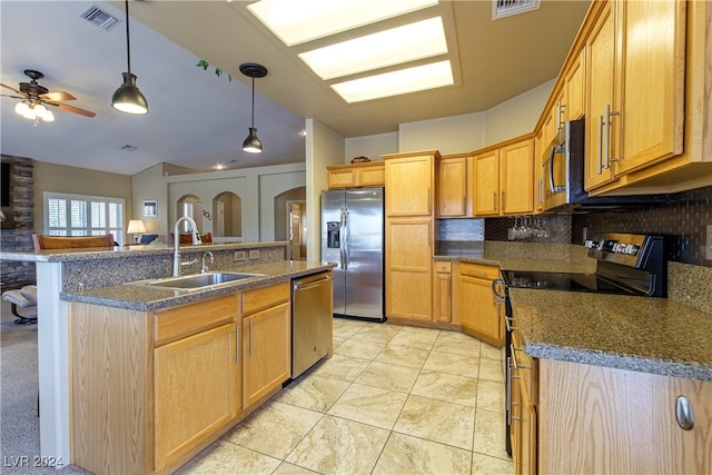 kitchen with ceiling fan, sink, a center island with sink, backsplash, and appliances with stainless steel finishes