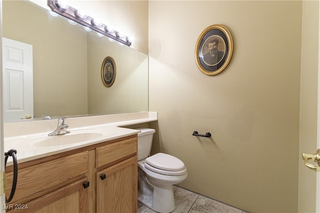 bathroom with tile patterned flooring, vanity, and toilet