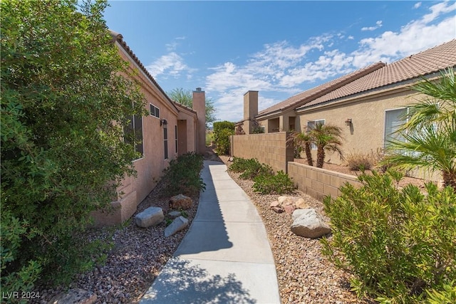 1214 Country Club Dr, Laughlin, NV 89029 - view of side of home with stucco siding, a tile roof, and fence