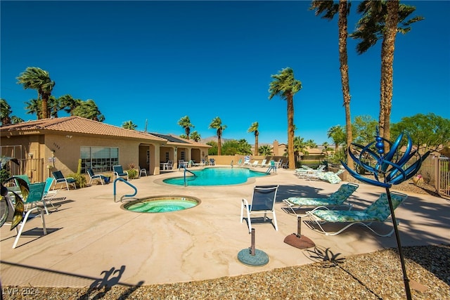 view of pool with a hot tub and a patio area