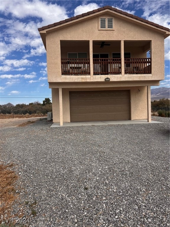 view of front of home with a balcony, a garage, and ceiling fan