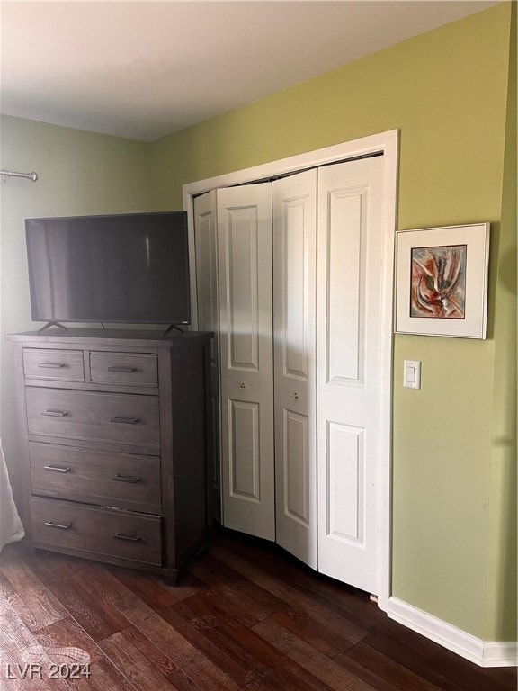 unfurnished bedroom with a closet and dark hardwood / wood-style flooring