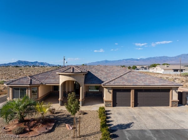 single story home with a garage and a mountain view