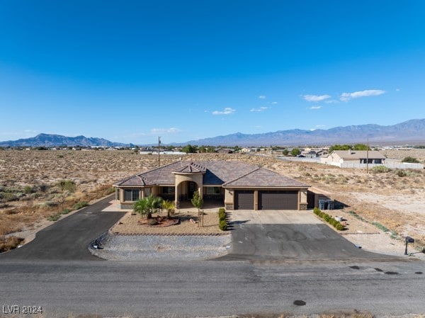 ranch-style house featuring a garage and a mountain view