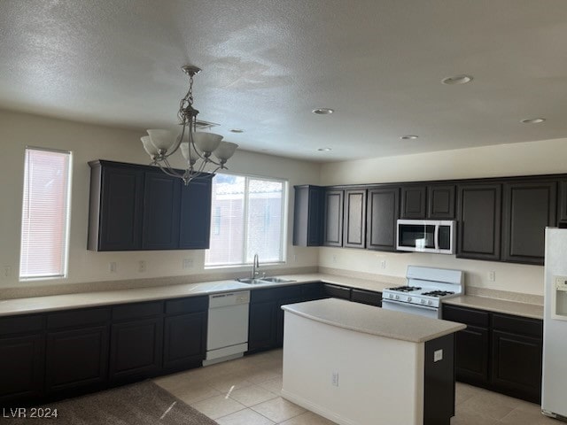 kitchen featuring pendant lighting, light tile patterned flooring, sink, a notable chandelier, and white appliances