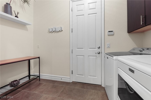 laundry area featuring cabinets, washer and dryer, and dark tile patterned floors