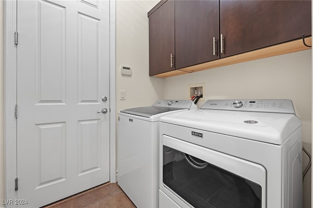 laundry area with cabinets, light tile patterned floors, and washing machine and dryer