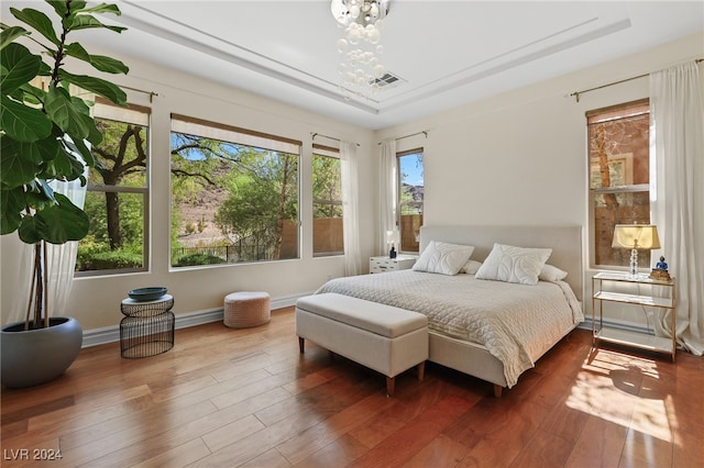 bedroom with an inviting chandelier and dark hardwood / wood-style flooring