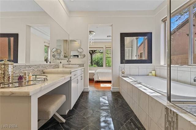 bathroom featuring tiled bath and vanity