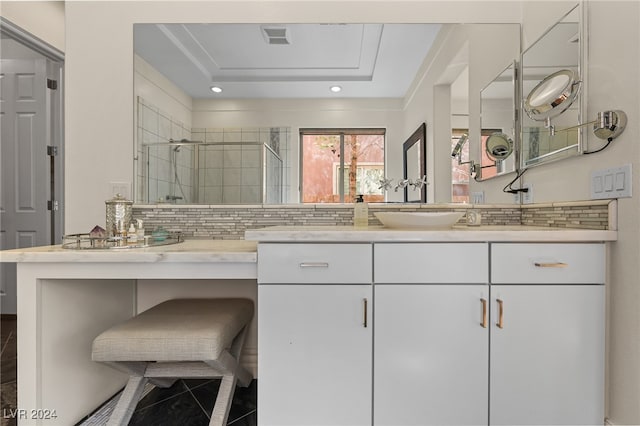 bathroom featuring walk in shower, vanity, and tasteful backsplash