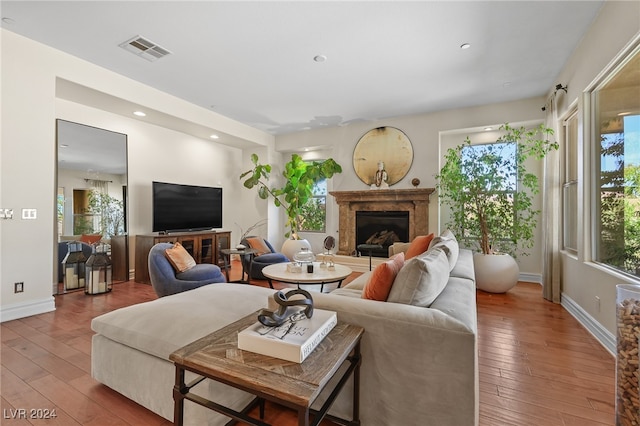 living room featuring a premium fireplace and hardwood / wood-style flooring