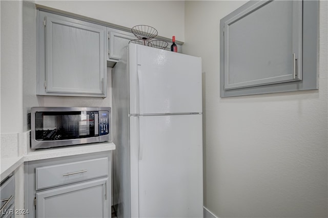 kitchen with white refrigerator and gray cabinets