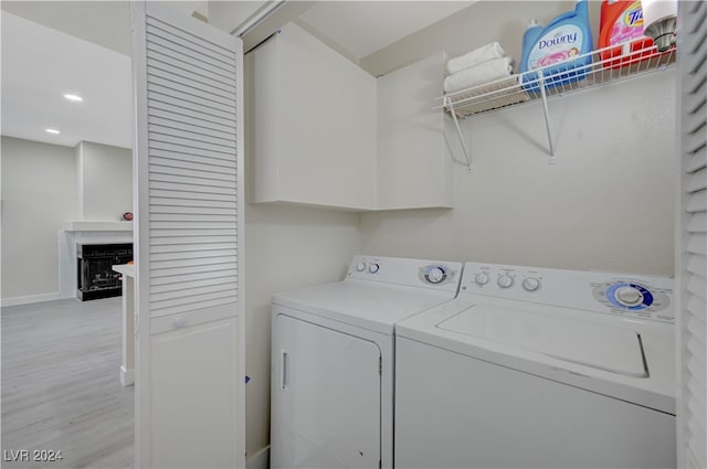 clothes washing area featuring light wood-type flooring and washing machine and dryer