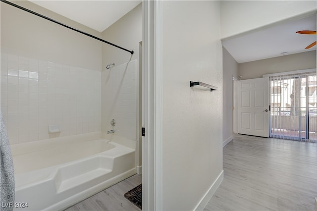 bathroom with shower / bathtub combination with curtain, wood-type flooring, and ceiling fan