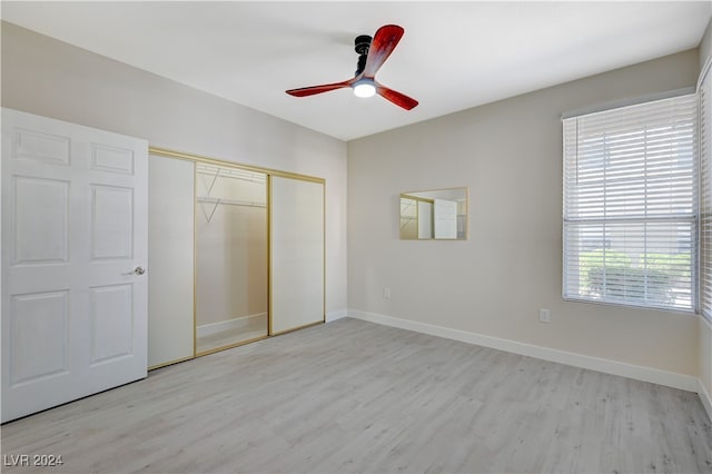 unfurnished bedroom with ceiling fan, a closet, and light hardwood / wood-style floors