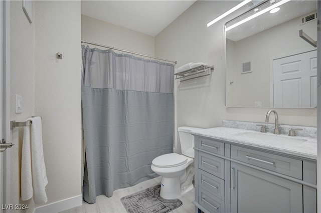 bathroom with walk in shower, vanity, and toilet