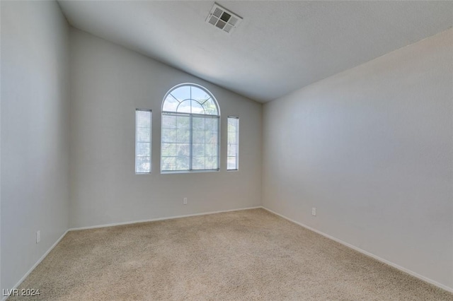 empty room with lofted ceiling and light colored carpet