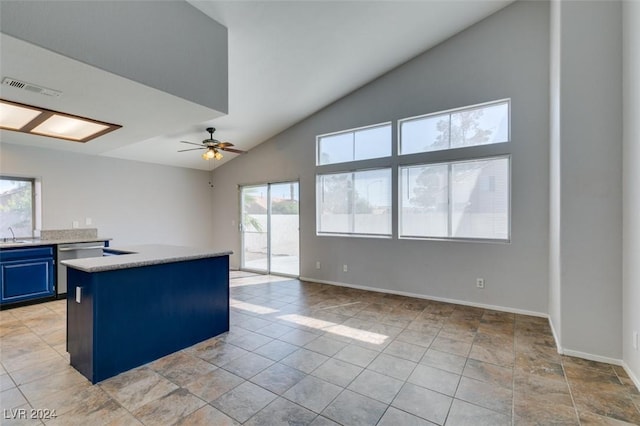 kitchen with ceiling fan, blue cabinetry, dishwasher, vaulted ceiling, and sink