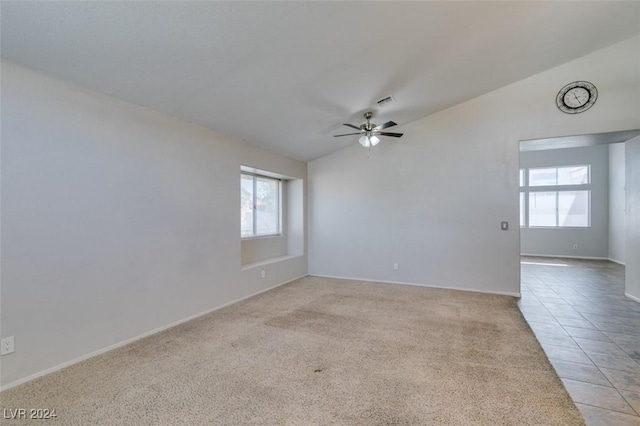 spare room featuring ceiling fan, light tile patterned floors, and lofted ceiling