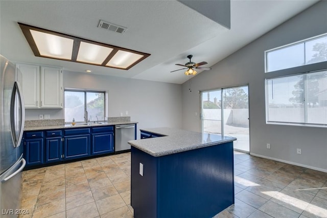 kitchen with white cabinetry, stainless steel appliances, a healthy amount of sunlight, blue cabinets, and vaulted ceiling