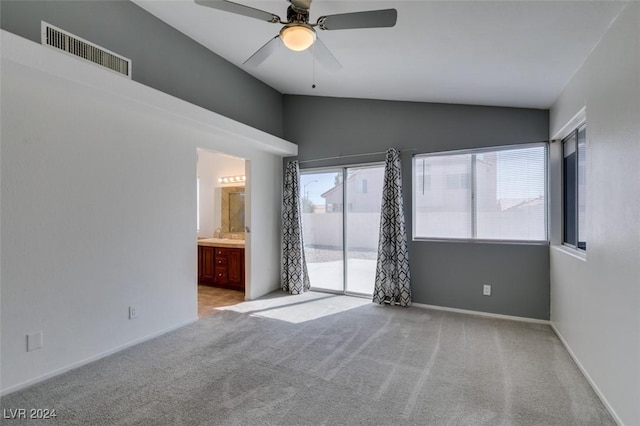 empty room featuring light carpet, ceiling fan, and vaulted ceiling