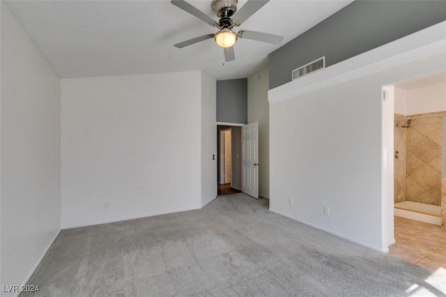 empty room featuring ceiling fan, light carpet, and a towering ceiling