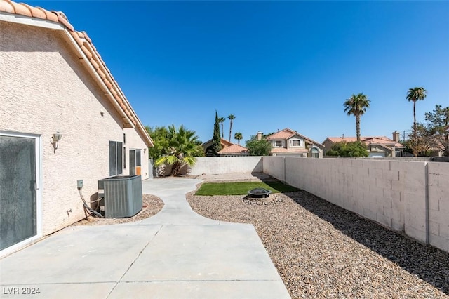 view of yard featuring a patio area, cooling unit, and a fire pit