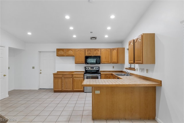 kitchen featuring sink, stainless steel electric range oven, light tile patterned floors, tile counters, and kitchen peninsula