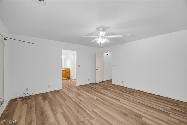 unfurnished bedroom featuring light wood-type flooring, ceiling fan, and connected bathroom