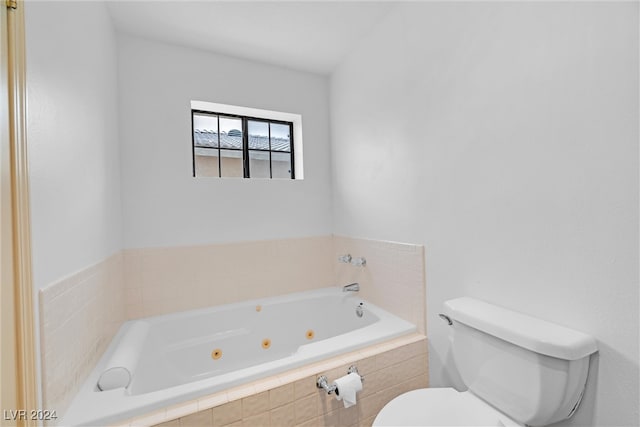 bathroom with tiled tub and toilet