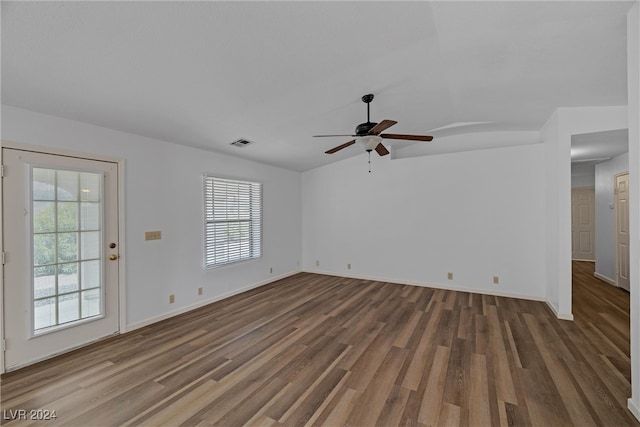 empty room with ceiling fan, dark hardwood / wood-style flooring, and vaulted ceiling