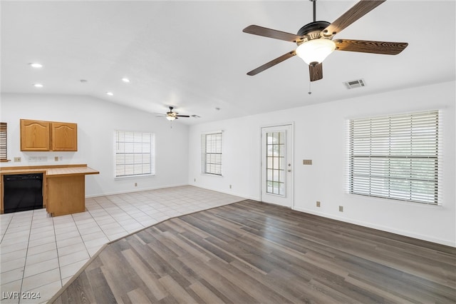 unfurnished living room with ceiling fan, plenty of natural light, vaulted ceiling, and light hardwood / wood-style flooring