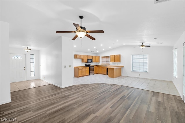 kitchen featuring vaulted ceiling, electric range, ceiling fan, light wood-type flooring, and kitchen peninsula