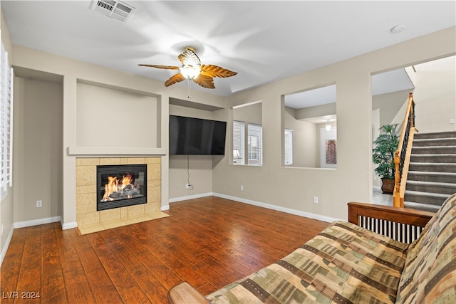 unfurnished living room with dark hardwood / wood-style floors, ceiling fan, and a tile fireplace