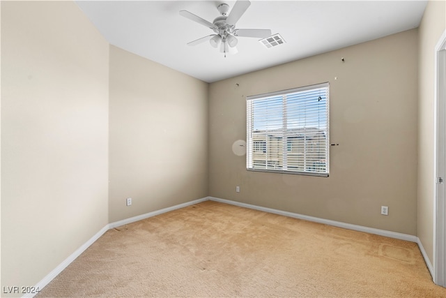 carpeted spare room with ceiling fan