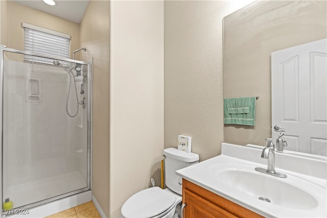 bathroom featuring tile patterned floors, vanity, a shower with shower door, and toilet