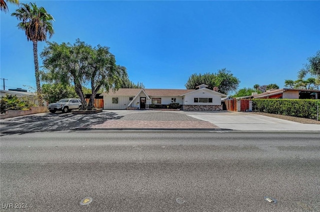 ranch-style house featuring decorative driveway and fence