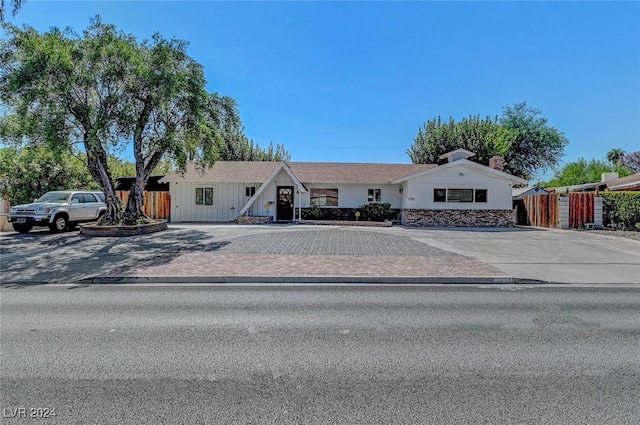 ranch-style house with decorative driveway and fence