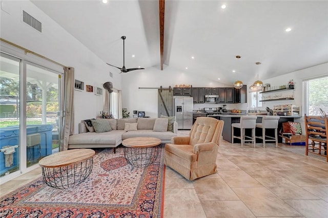 living area with light tile patterned floors, high vaulted ceiling, a barn door, visible vents, and beam ceiling