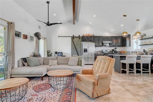 living room featuring high vaulted ceiling, a barn door, beamed ceiling, and a ceiling fan